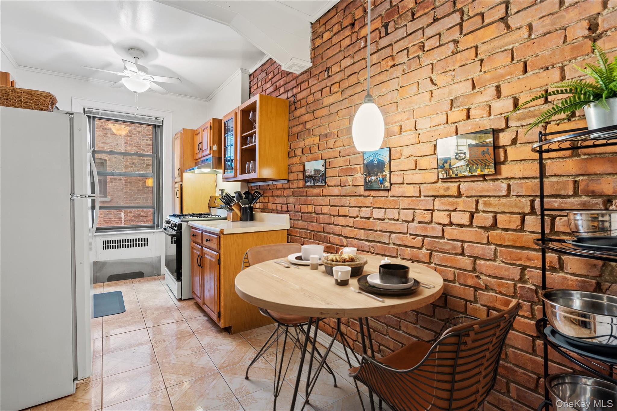 76-66 Austin Street, Unit 4B Queens, NY 11375 - Photo 3 of 12 Kitchen with freestanding refrigerator, light countertops, brown cabinets, crown molding, and range with gas stovetop