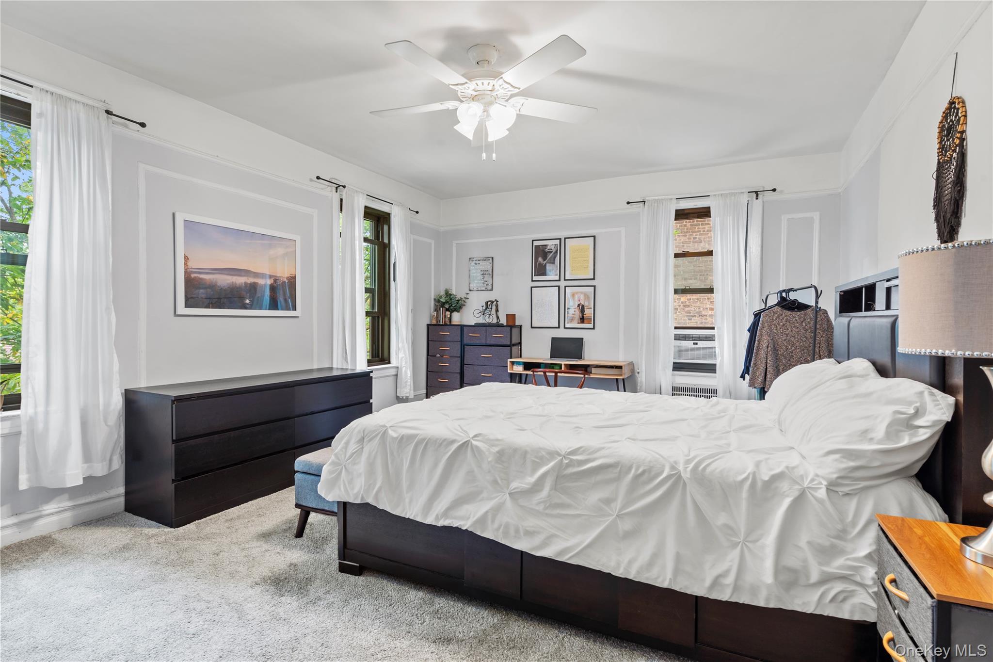 76-66 Austin Street, Unit 4B Queens, NY 11375 - Photo 5 of 12 Carpeted bedroom featuring multiple windows and a ceiling fan