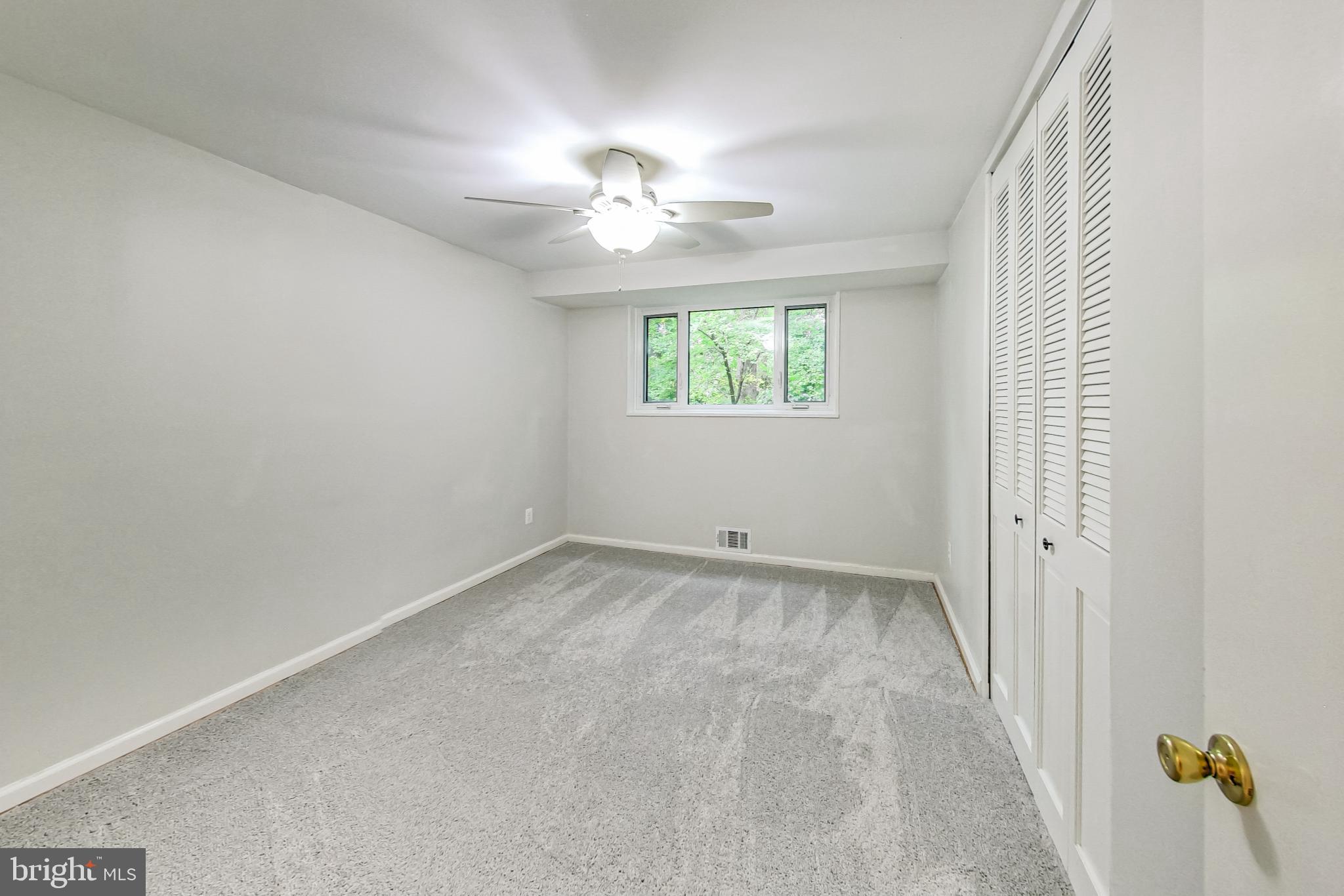 10501 Montrose Avenue, Unit 103 Bethesda, MD 20814 - Photo 25 of 27 an empty room with windows and chandelier fan