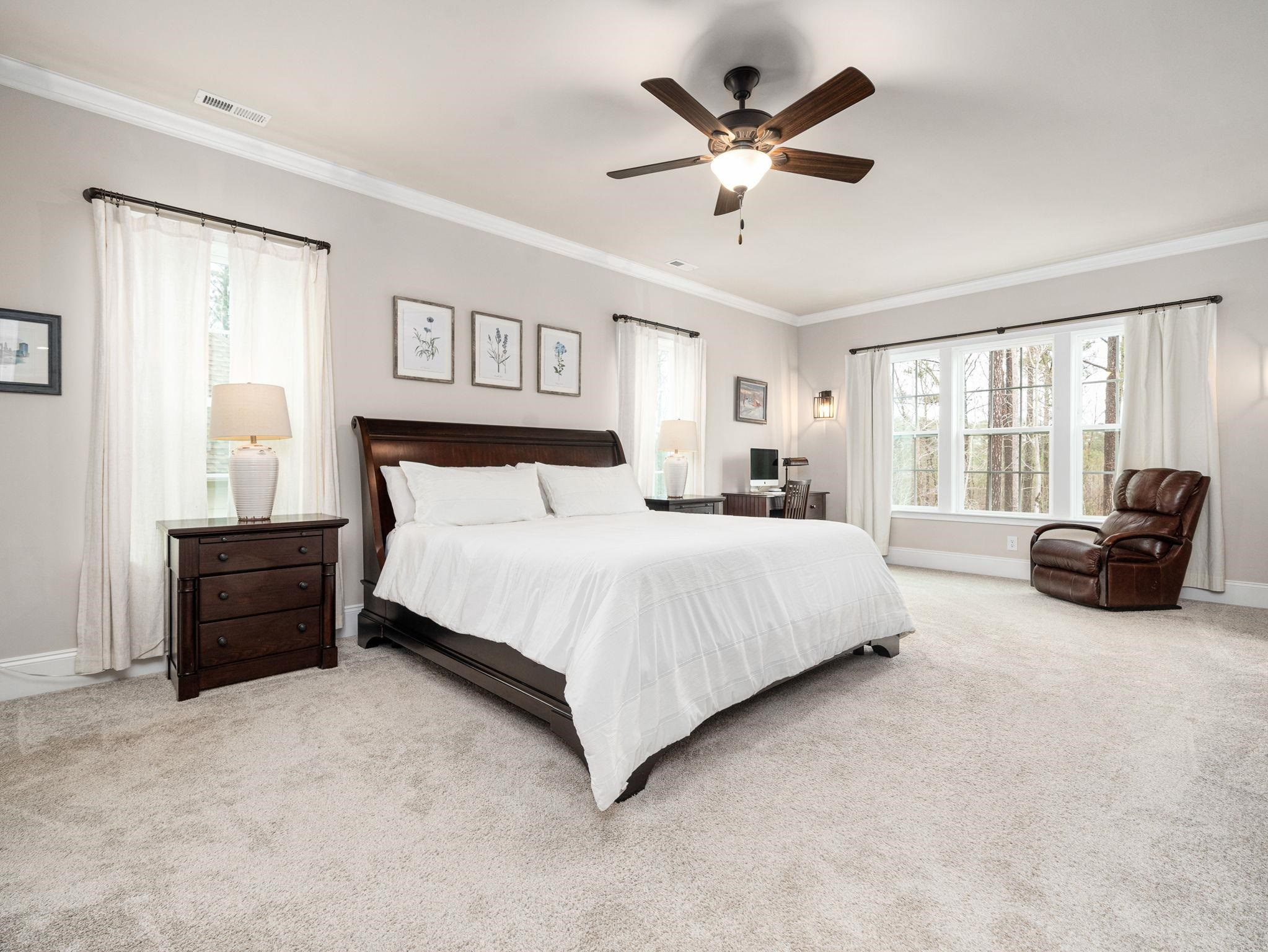 7532 Hasentree Way Wake Forest, NC 27587 - Photo 23 of 40 a spacious bedroom with a bed a couch and a large window