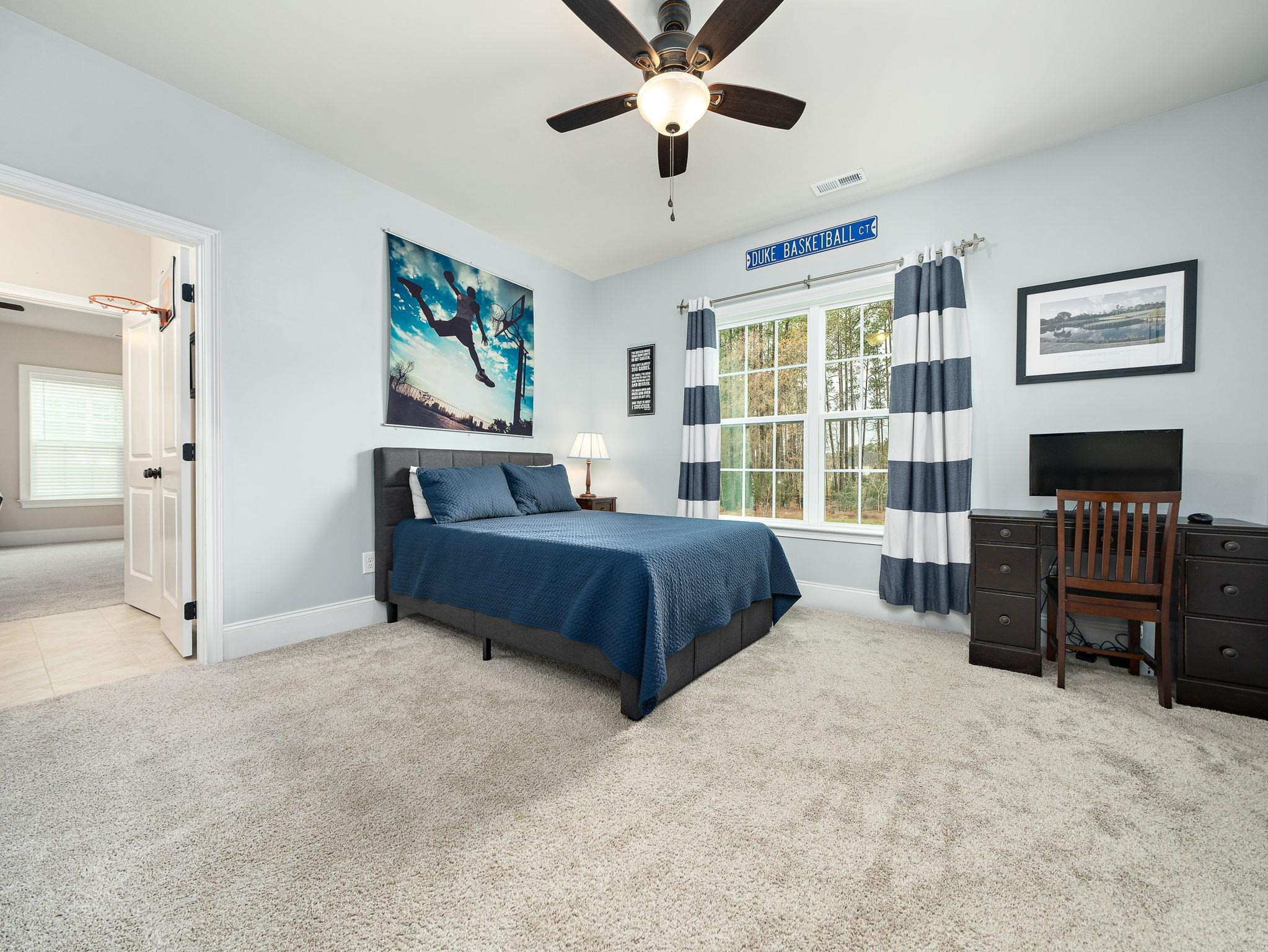 7532 Hasentree Way Wake Forest, NC 27587 - Photo 28 of 40 a bedroom with a large bed a chandelier and windows