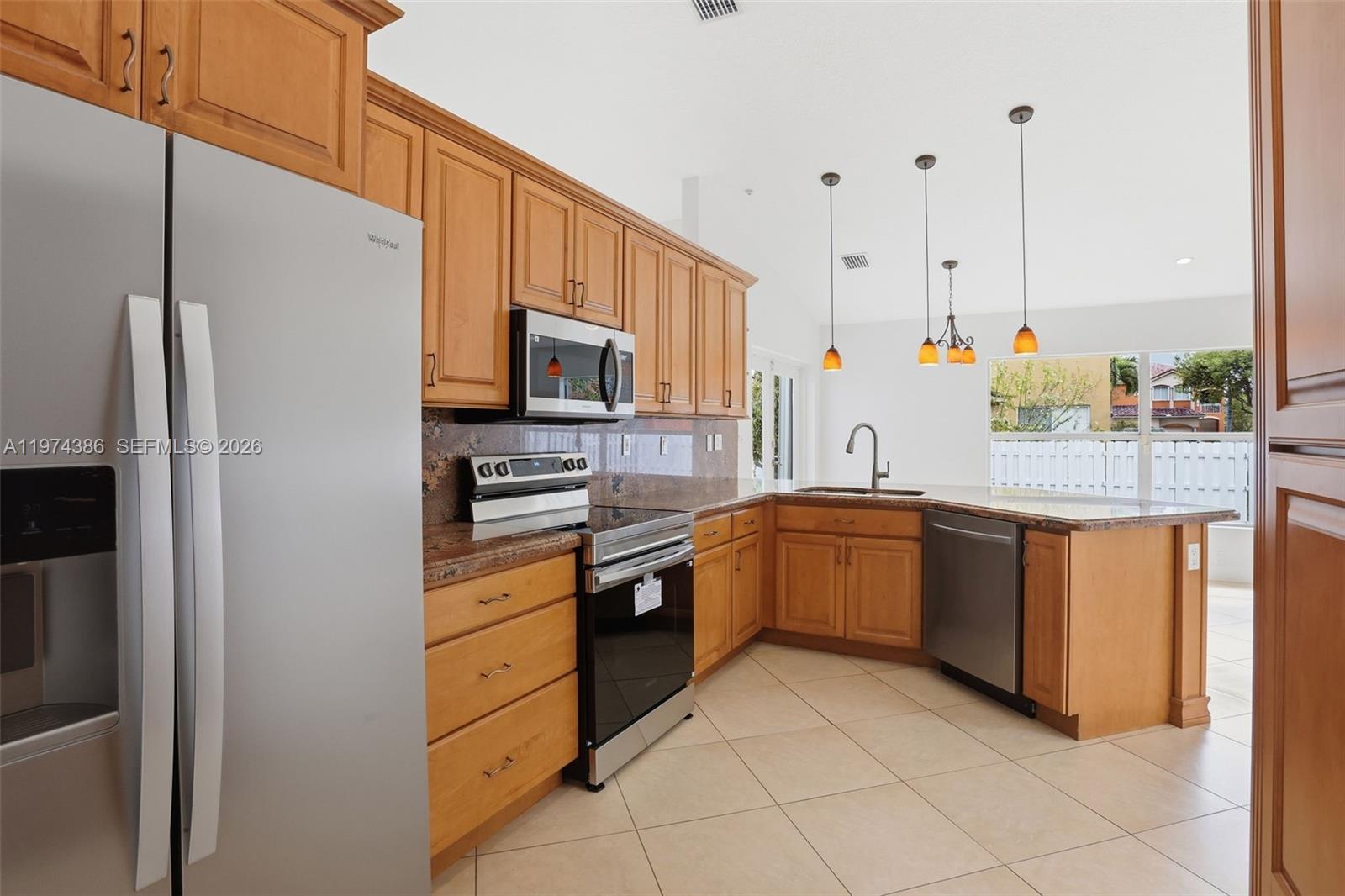 12930 Southwest 20th Street Miramar, FL 33027 - Photo 11 of 48 a kitchen with stainless steel appliances granite countertop a refrigerator and a stove top oven