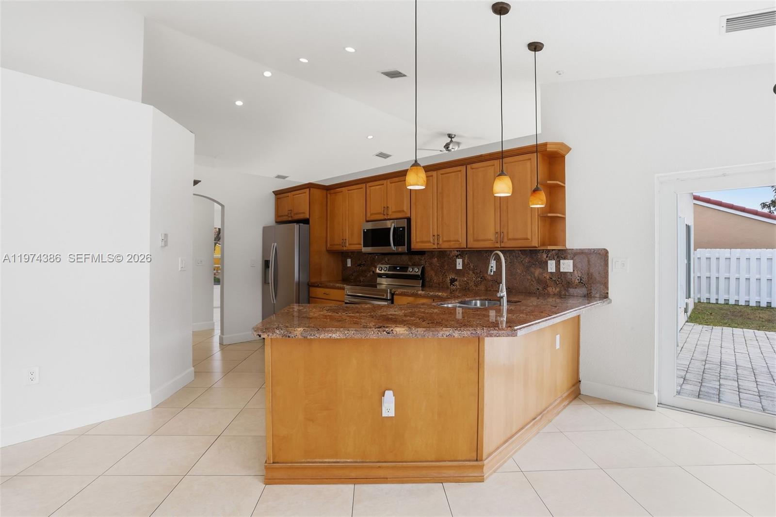 12930 Southwest 20th Street Miramar, FL 33027 - Photo 14 of 48 a kitchen with stainless steel appliances granite countertop a stove and a refrigerator