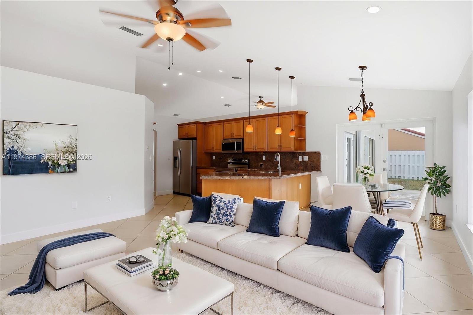 12930 Southwest 20th Street Miramar, FL 33027 - Photo 16 of 48 a living room with furniture a chandelier and a flat screen tv