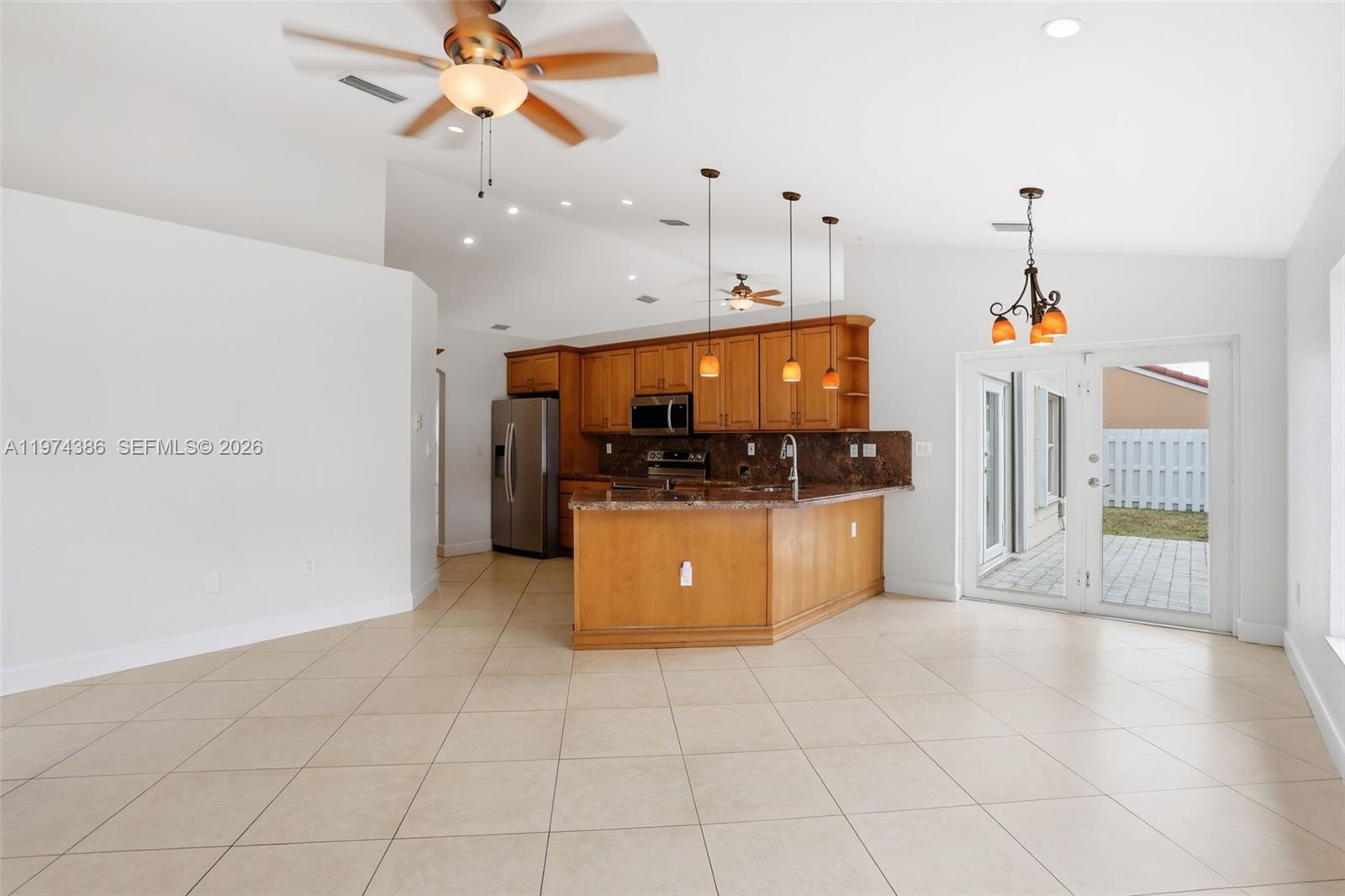 12930 Southwest 20th Street Miramar, FL 33027 - Photo 17 of 48 a kitchen with stainless steel appliances kitchen island granite countertop a refrigerator a oven a sink and dishwasher