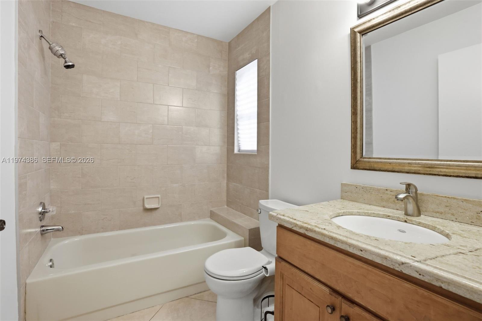 12930 Southwest 20th Street Miramar, FL 33027 - Photo 29 of 48 a bathroom with a granite countertop toilet a sink and a bathtub