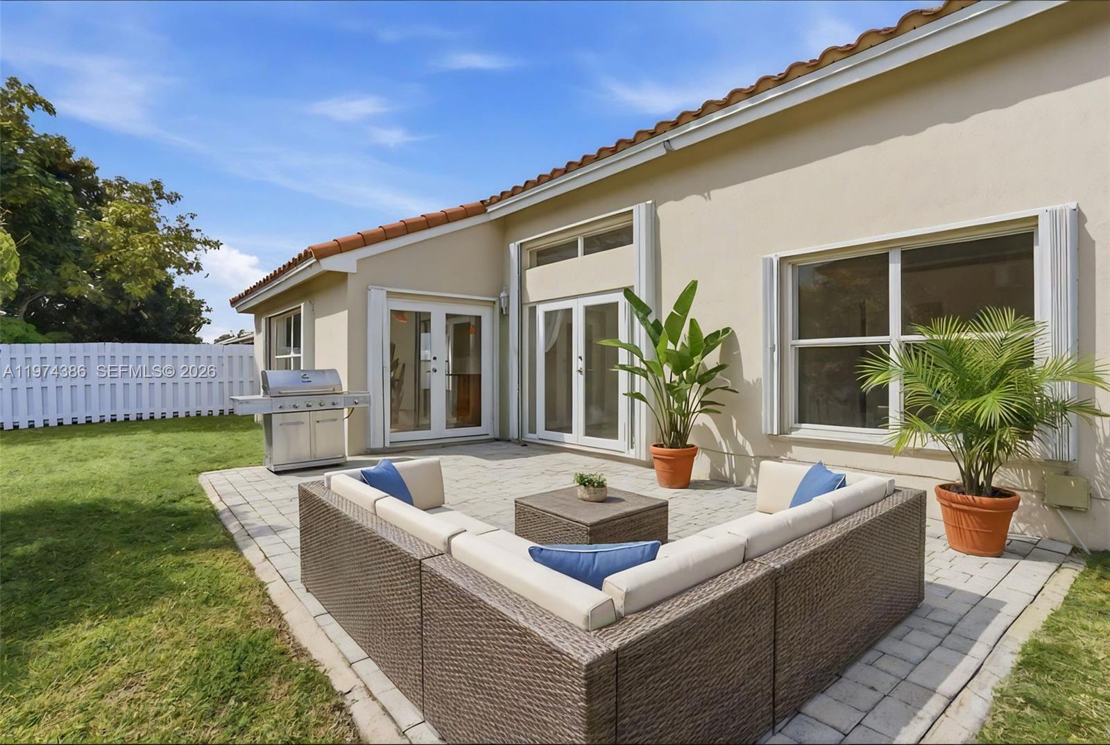 12930 Southwest 20th Street Miramar, FL 33027 - Photo 40 of 48 a view of a house and a swimming pool with a couches chairs and wooden fence