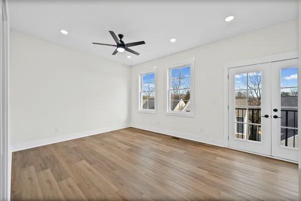 an empty room with wooden floor and windows