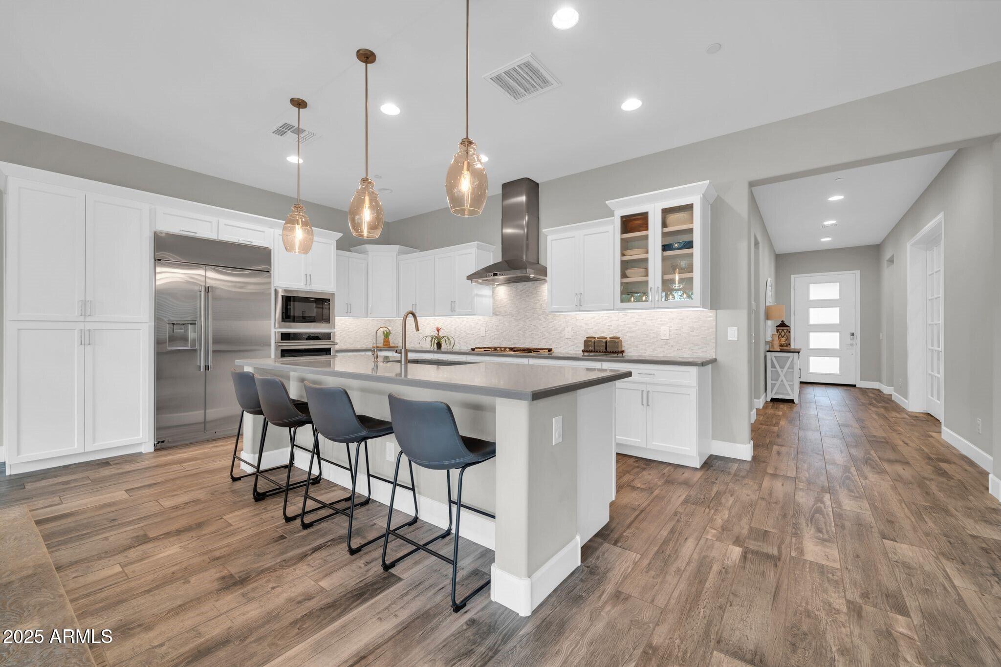 17565 Blaze Lane Rio Verde, AZ 85263 - Photo 8 of 43 a kitchen with stainless steel appliances kitchen island hardwood floor sink and stove