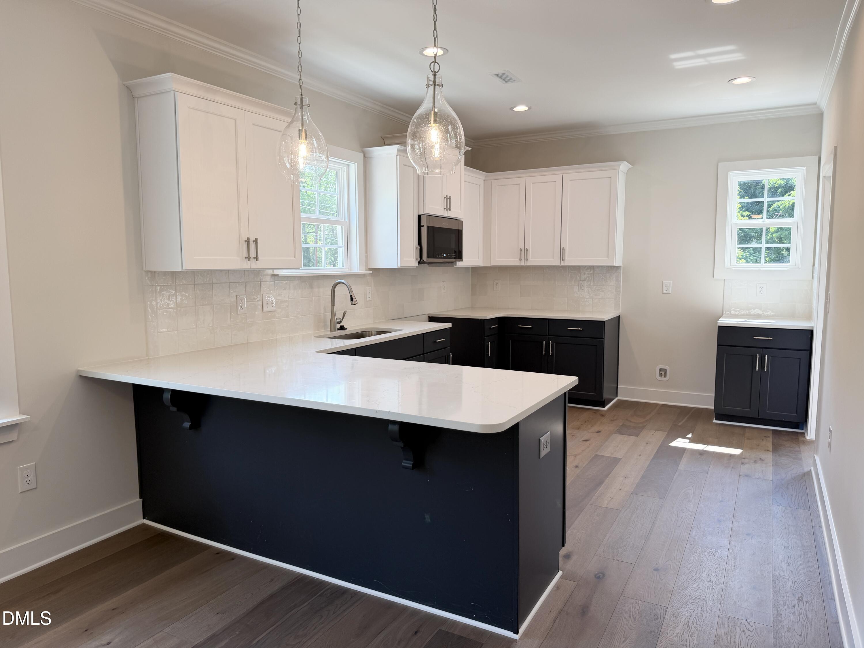 1122 Berkeley Street Durham, NC 27705 - Photo 9 of 29 a kitchen with granite countertop a sink cabinets and wooden floor
