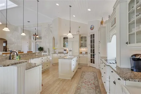 a large kitchen with kitchen island a large counter space a sink stainless steel appliances and cabinets