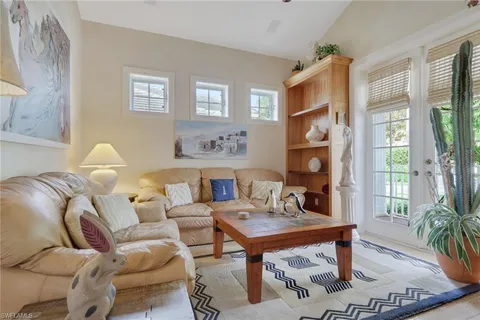 a living room with furniture a flat screen tv and a table