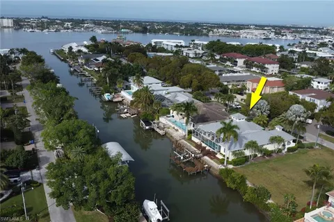 an aerial view of ocean and residential houses with outdoor space