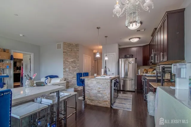 a living room with kitchen island furniture and a chandelier