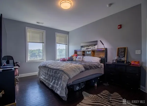 a bedroom with a bed and wooden floor