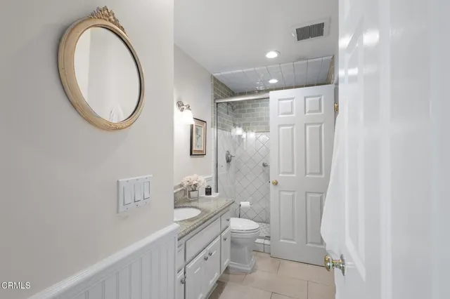 a bathroom with a granite countertop sink a toilet and a mirror