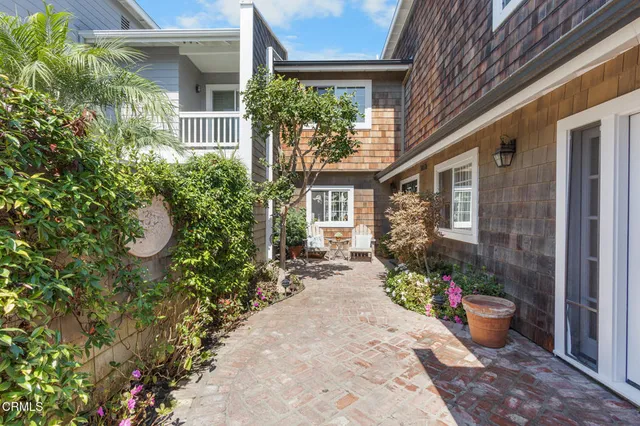 a front view of a house with potted plants