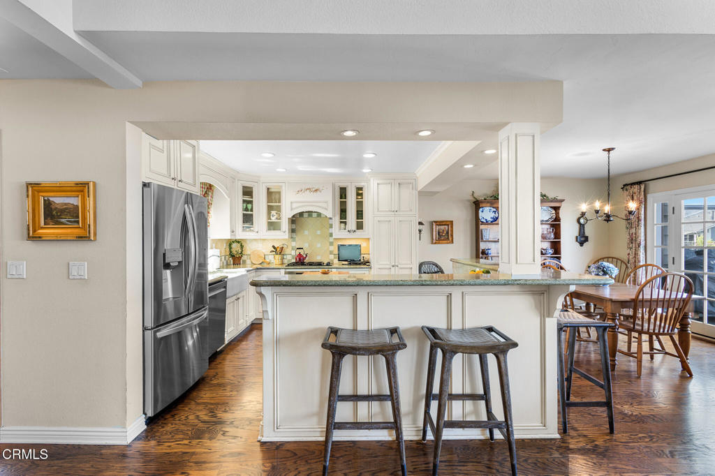 4505 Gateshead Bay Oxnard, CA 93035 - Photo 7 of 41 a kitchen with stainless steel appliances granite countertop a dining table chairs refrigerator and sink