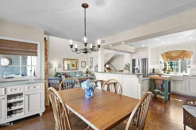 a view of a dining room and livingroom with furniture wooden floor a chandelier