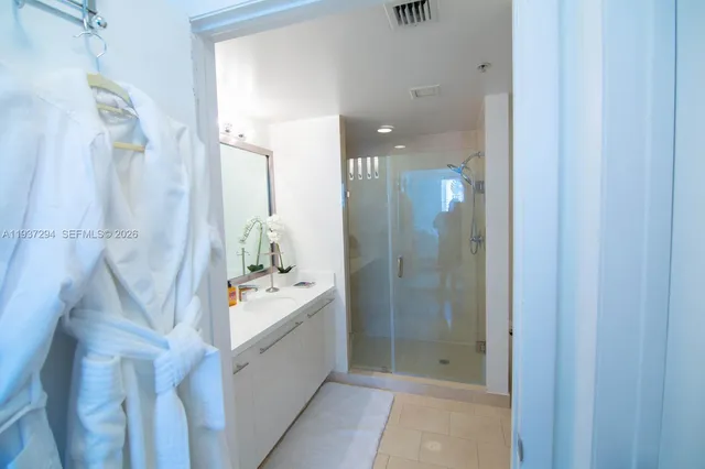 a bathroom with a mirror a sink a shower and a mirror