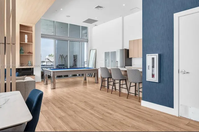 a living room with furniture a wooden floor and a kitchen view