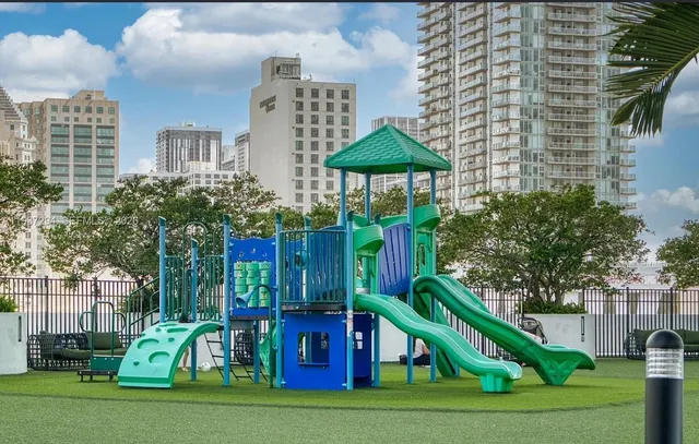 a view of a multi story residential apartment building with a yard