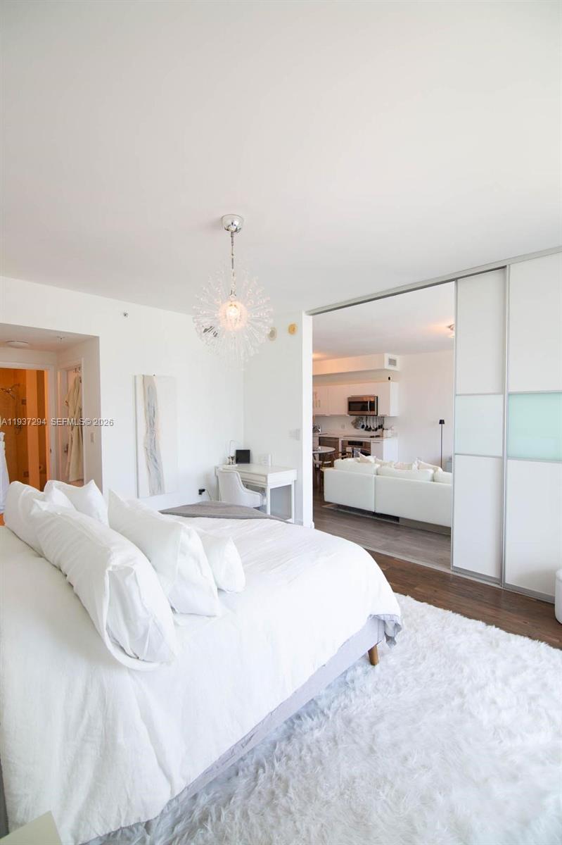 90 Southwest 3rd Street, Unit 2703 Miami, FL 33130 - Photo 10 of 28 a spacious bedroom with a bed and a large mirror