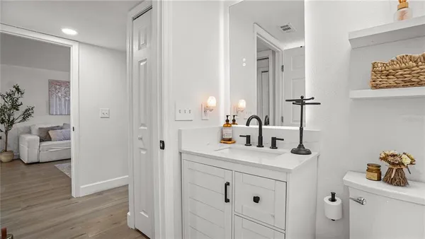 a en suite bathroom with a granite countertop sink and a mirror