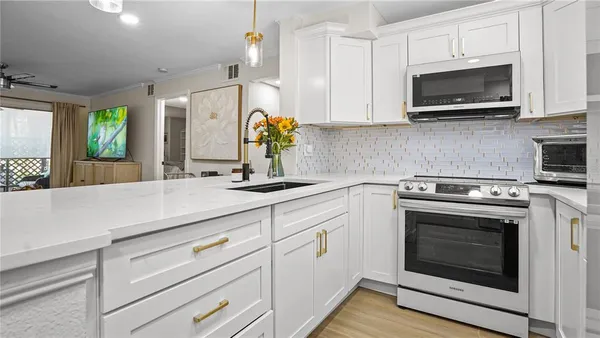 a kitchen with stainless steel appliances white cabinets and a stove top oven