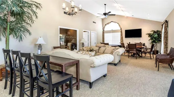a living room with furniture a flat screen tv and a chandelier