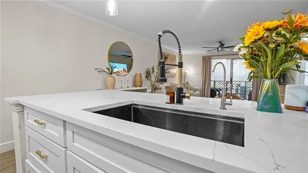 a kitchen with a sink and a stove with wooden floor