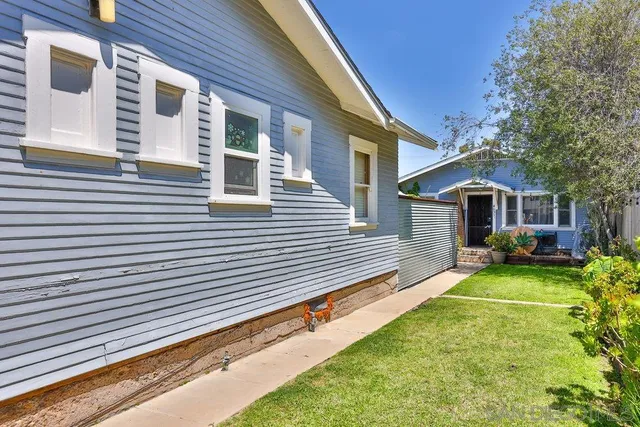 a view of a house with backyard and sitting area