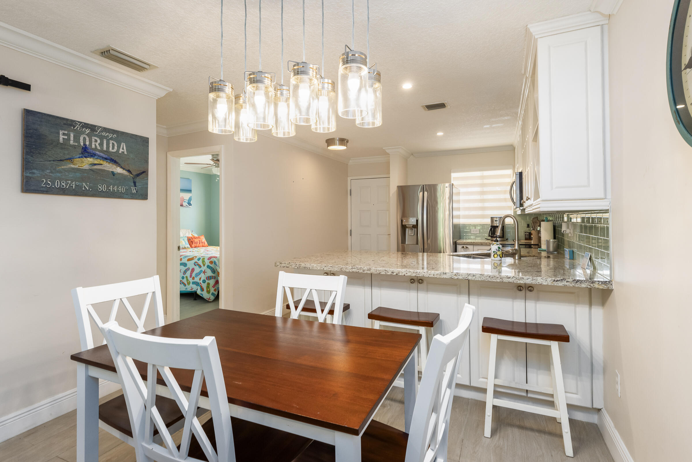 98222 Windward Avenue Key Largo, FL 33037 - Photo 11 of 41 a dining room with a table chairs and kitchen view