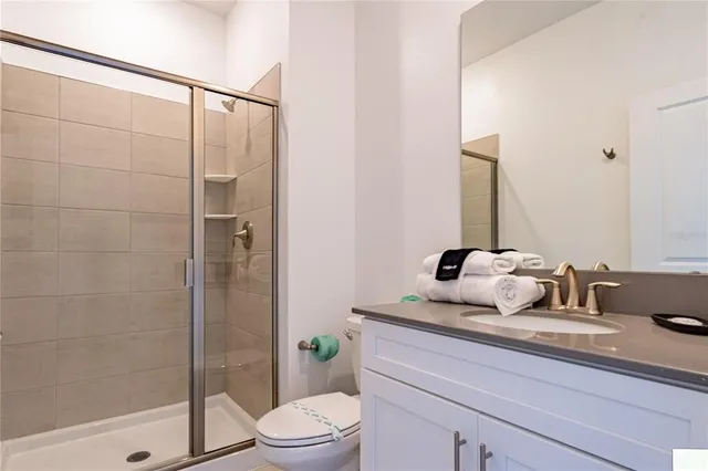 a bathroom with a granite countertop sink a toilet and shower