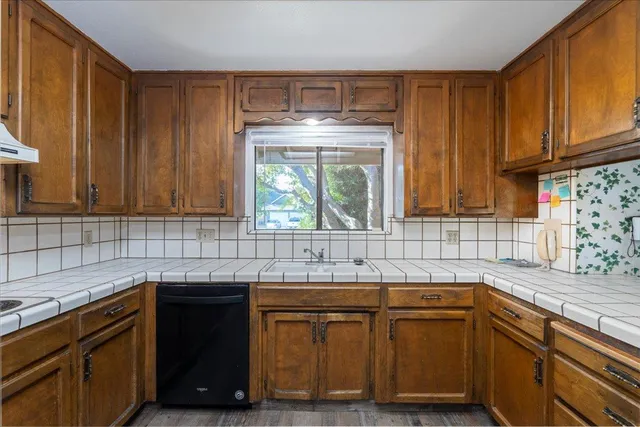a kitchen with granite countertop a sink and a stove