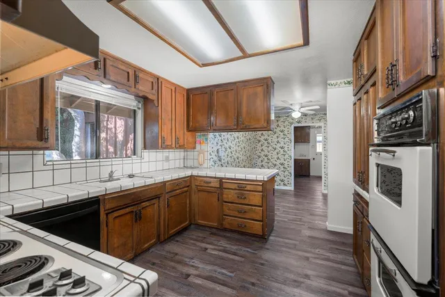a kitchen with stainless steel appliances granite countertop a sink a stove and a refrigerator