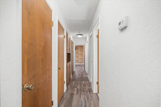 a view of a hallway with wooden floor and closet