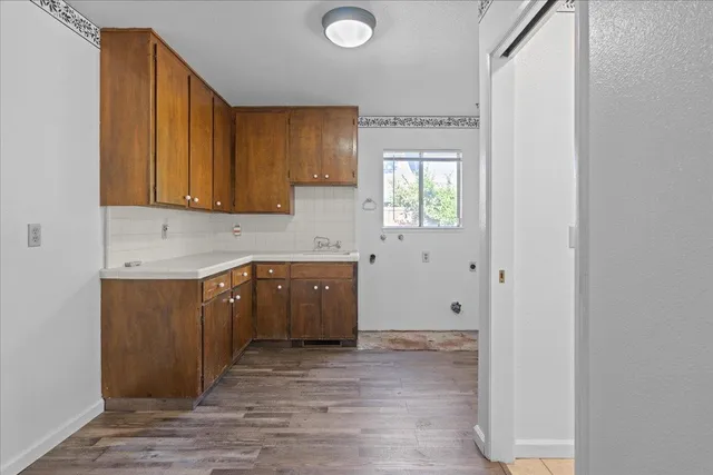 a view of a kitchen with wooden floor and electronic appliances