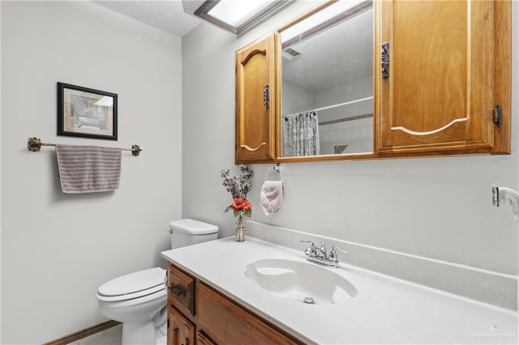 1909 Tyler Street Mission, TX 78572 - Photo 14 of 17 a bathroom with a sink a mirror and a toilet
