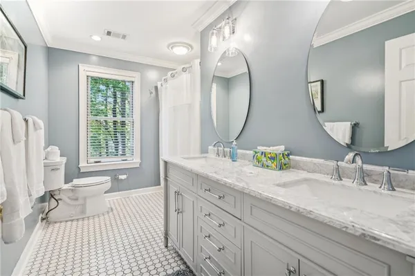a bathroom with a granite countertop toilet a sink and a mirror