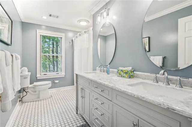 a bathroom with a granite countertop toilet a sink and a mirror