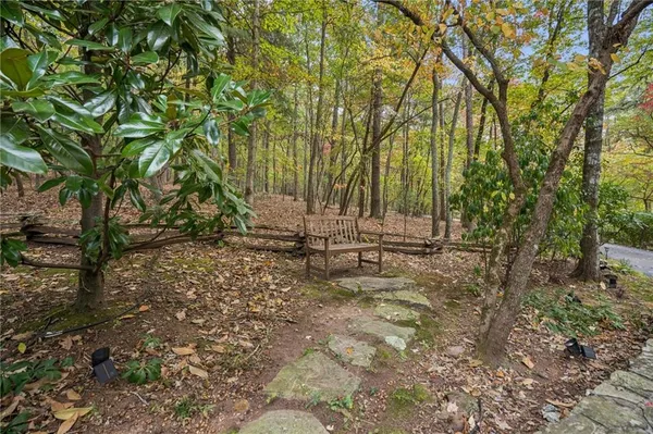 a view of a hallway with wooden floor and a bathroom