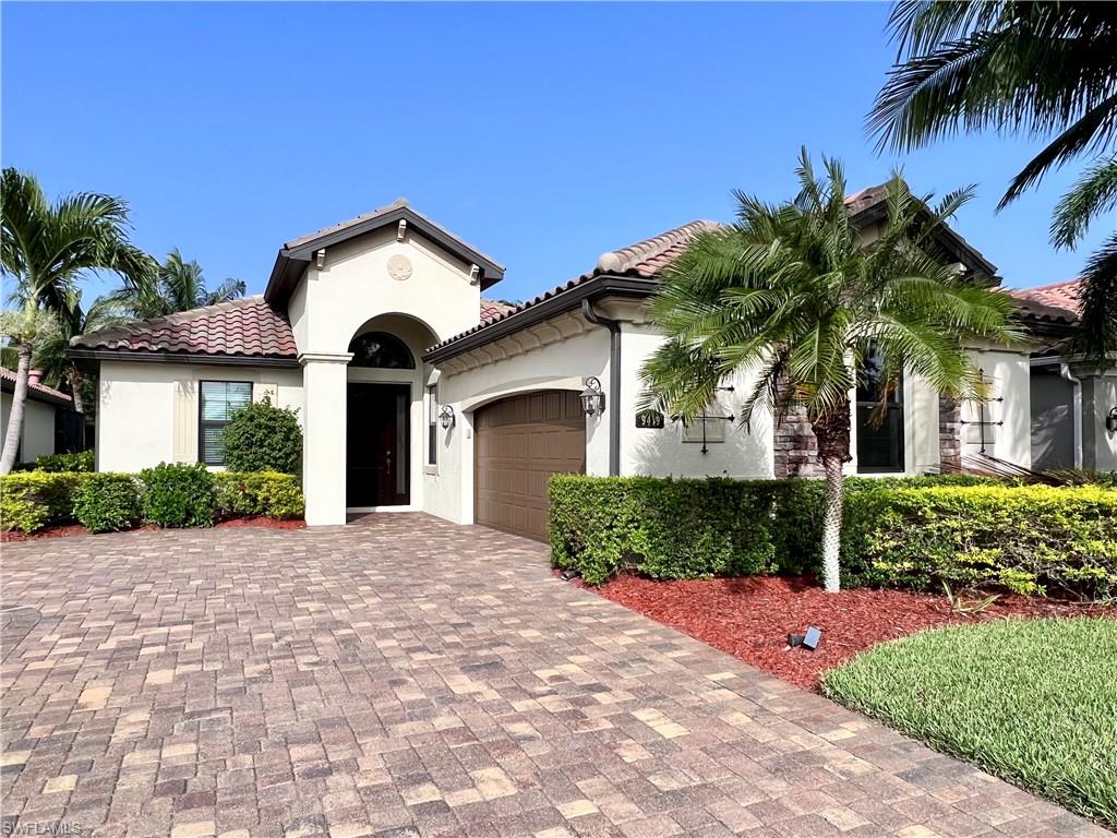 9419 Piacere Way Naples, FL 34113 - Photo 1 of 19 a front view of a house with a garden and palm trees