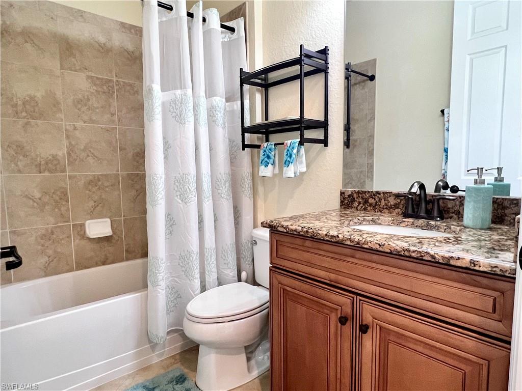 9419 Piacere Way Naples, FL 34113 - Photo 12 of 19 a bathroom with a granite countertop sink a toilet and shower