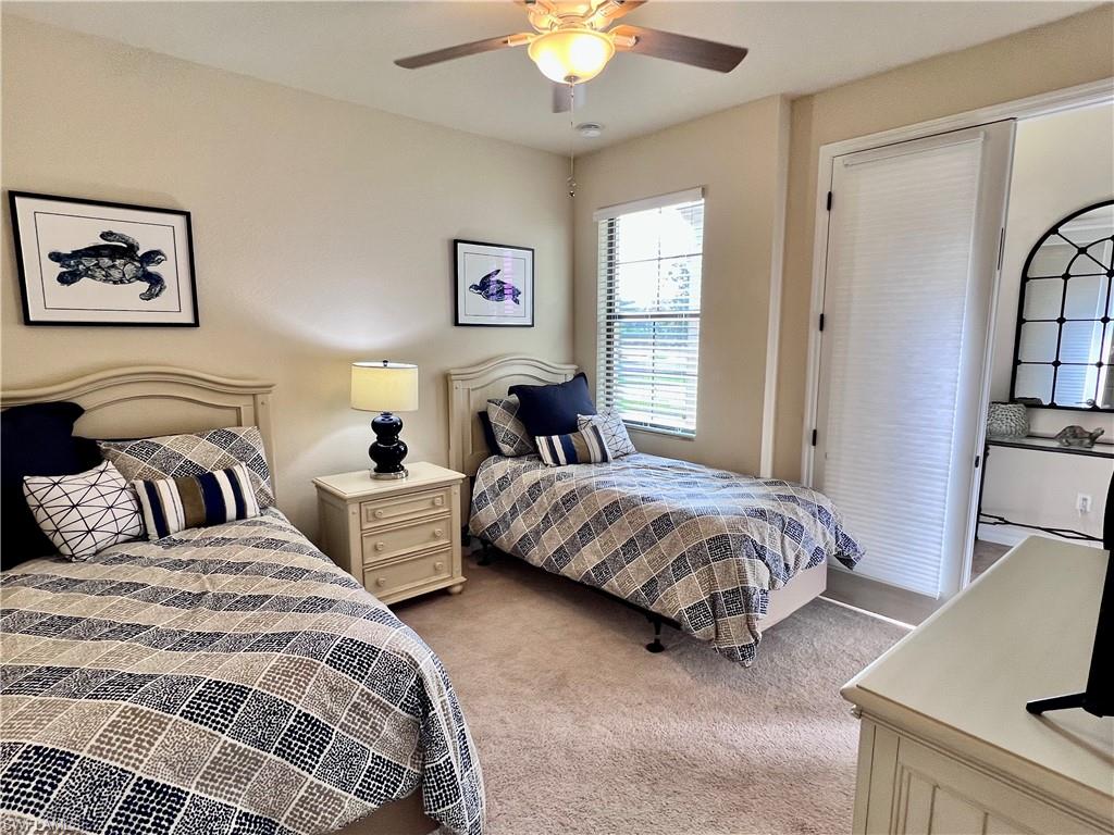 9419 Piacere Way Naples, FL 34113 - Photo 13 of 19 a spacious bedroom with two beds and a chandelier