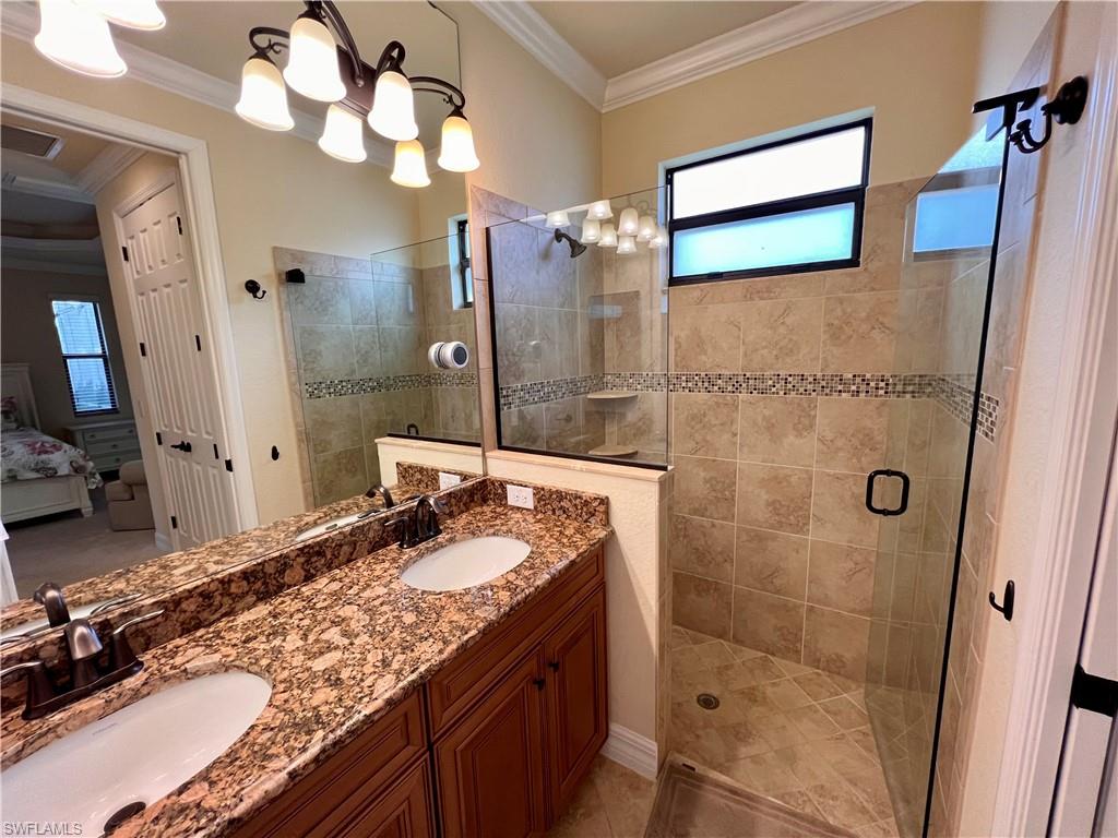 9419 Piacere Way Naples, FL 34113 - Photo 15 of 19 a bathroom with a granite countertop sink a large mirror and a shower