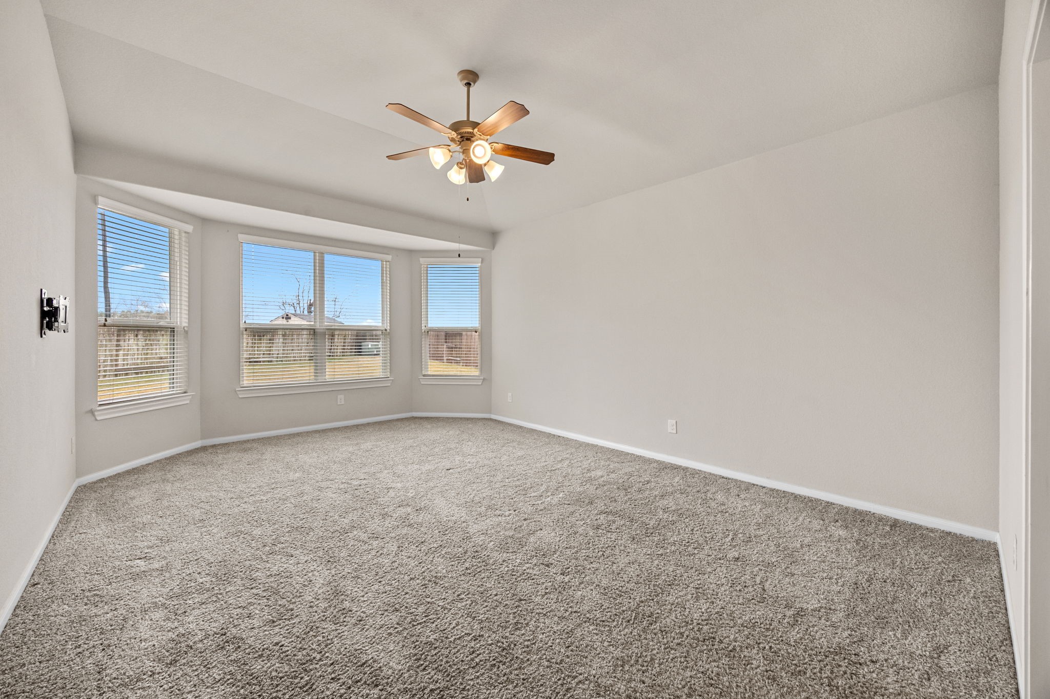 2406 Temple Crag Drive Rosharon, TX 77583 - Photo 13 of 26 The pretty primary bedroom is large and boasts high ceilings and plush, neutral carpet. The wall of windows fills the space with gorgeous, natural light and offers views of the huge, backyard.