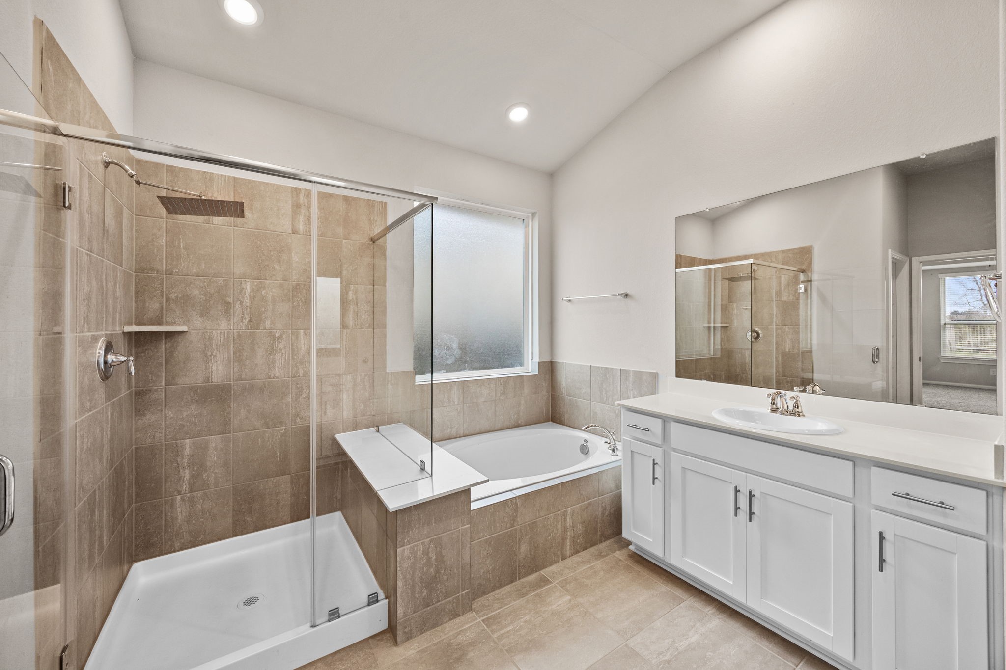 2406 Temple Crag Drive Rosharon, TX 77583 - Photo 15 of 26 The ensuite bath offers two vanities with expansive mirrors, a deep soaking tub and separate, glass-enclosed shower.