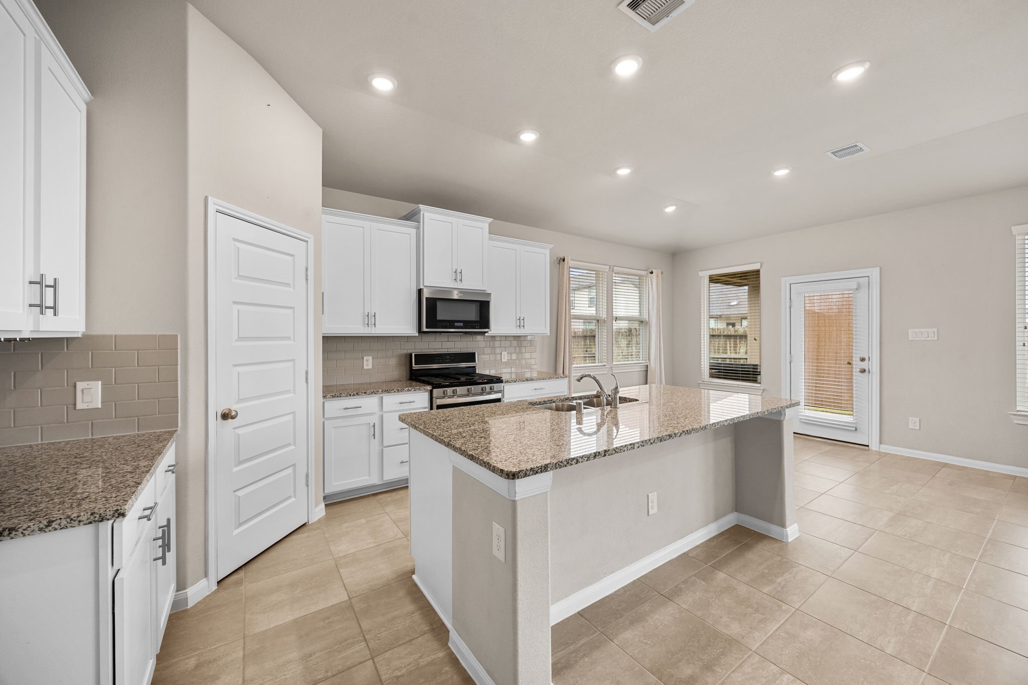 2406 Temple Crag Drive Rosharon, TX 77583 - Photo 9 of 26 The kitchen offers abundant cabinetry and granite countertops. The center island is perfect for extra seating and is a great spot for displaying and serving food while entertaining.