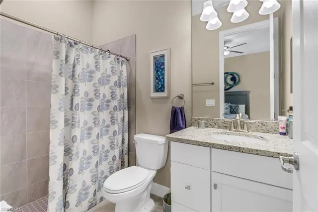 a bathroom with a granite countertop sink toilet mirror and shower